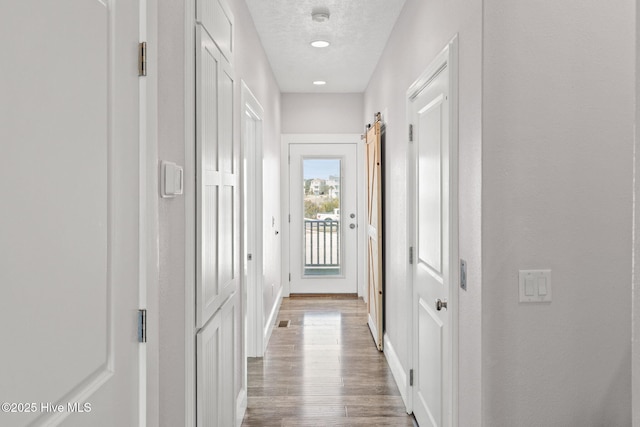 449 E Fourth St, Ocean Isle Beach, NC 28469 - hall with wood finished floors, baseboards, and a textured ceiling