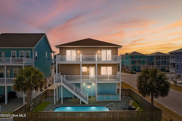 449 E Fourth St, Ocean Isle Beach, NC 28469 - rear view of property featuring a balcony, a fenced backyard, a patio, and stairs