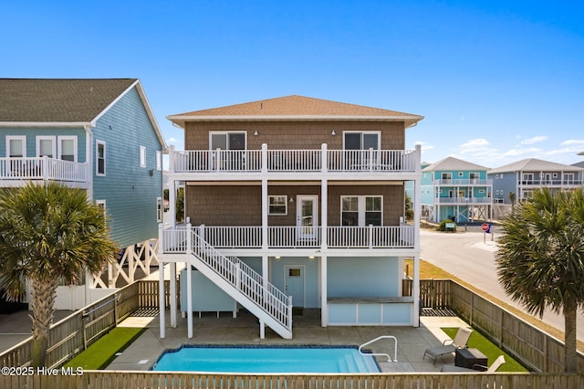449 E Fourth St, Ocean Isle Beach, NC 28469 - rear view of property with a fenced backyard, a patio, and a balcony