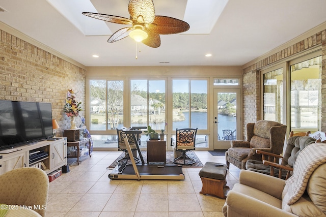 living area featuring light tile patterned flooring, a healthy amount of sunlight, and brick wall