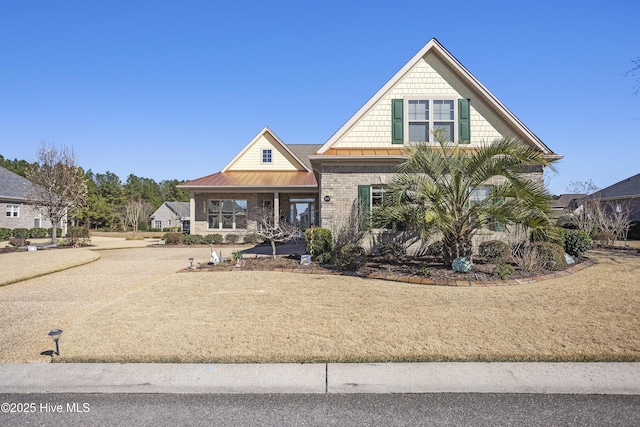 view of front of property with a standing seam roof, brick siding, and metal roof