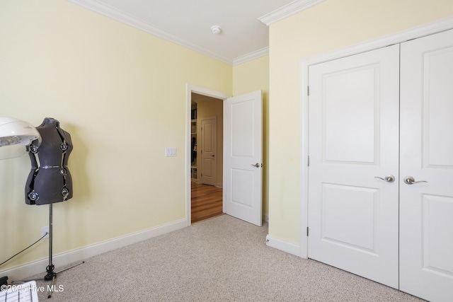 unfurnished bedroom featuring baseboards, carpet floors, and ornamental molding