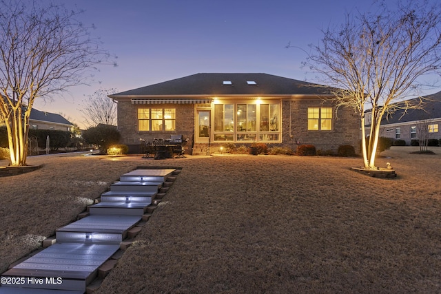 view of front of property featuring brick siding and a patio area