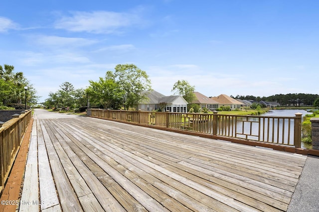 wooden terrace featuring a water view and a residential view