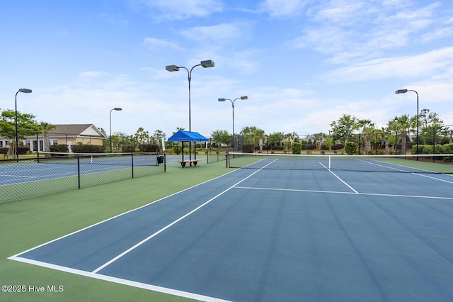 view of tennis court featuring fence