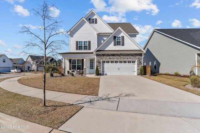 view of front of house with stone siding, a front lawn, concrete driveway, and an attached garage