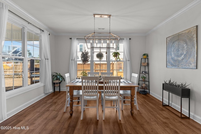 dining space with plenty of natural light, wood finished floors, and crown molding