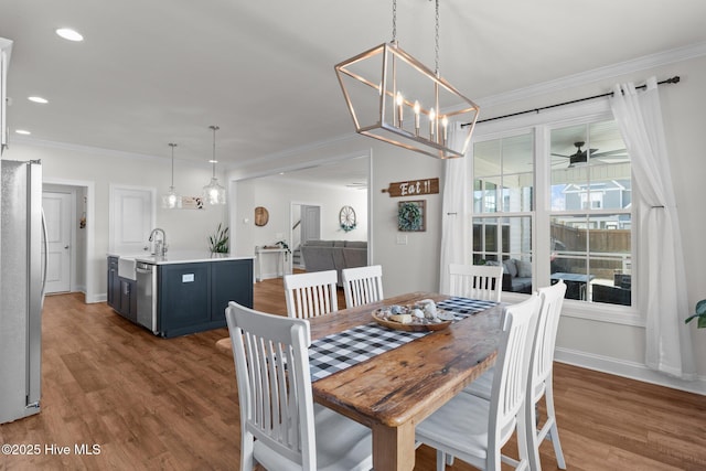 dining area featuring crown molding, wood finished floors, and baseboards