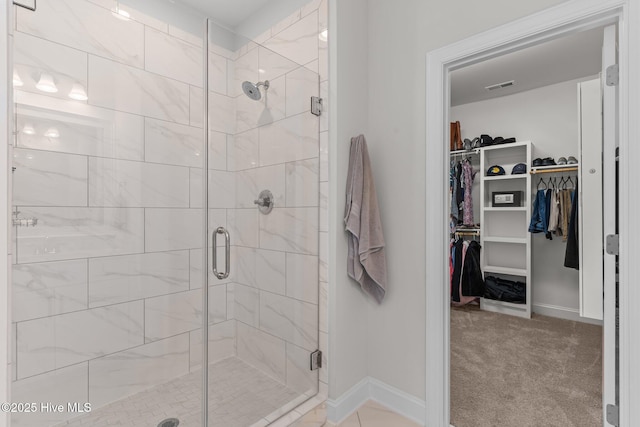 full bathroom with a stall shower, visible vents, baseboards, and a walk in closet