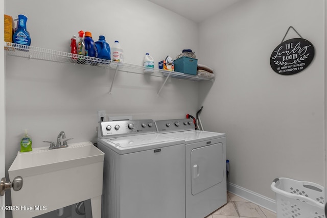 laundry area featuring laundry area, washer and dryer, baseboards, and a sink