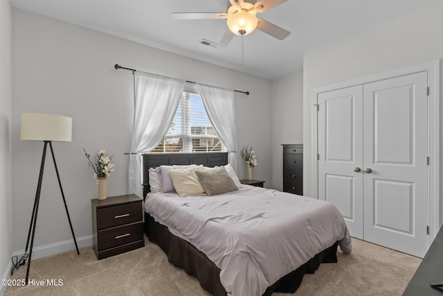 bedroom featuring visible vents, a closet, baseboards, light colored carpet, and ceiling fan