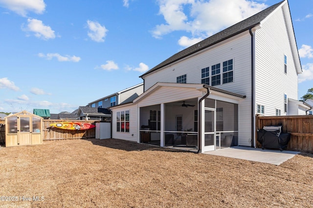 rear view of property featuring ceiling fan, a sunroom, a fenced backyard, a yard, and a patio area