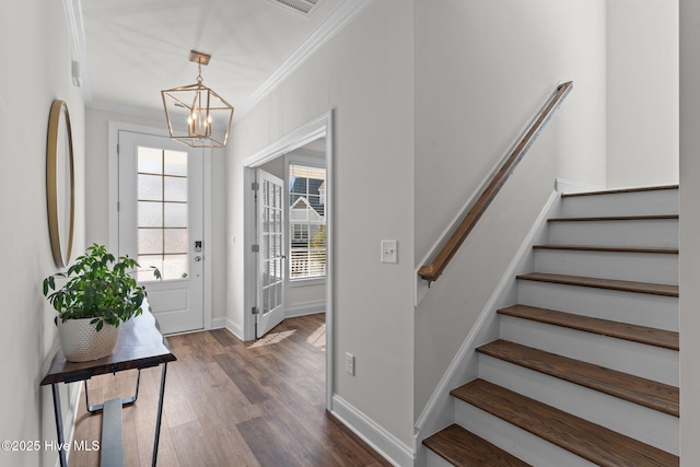 foyer with baseboards, a chandelier, stairs, ornamental molding, and dark wood-style flooring