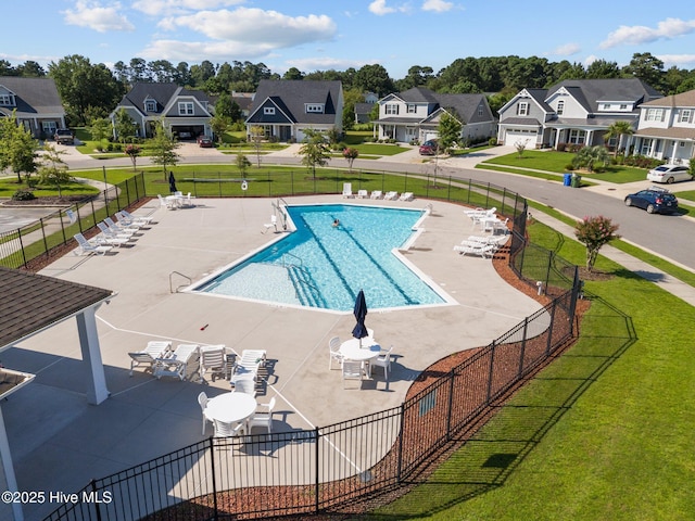 pool featuring a yard, a residential view, and fence