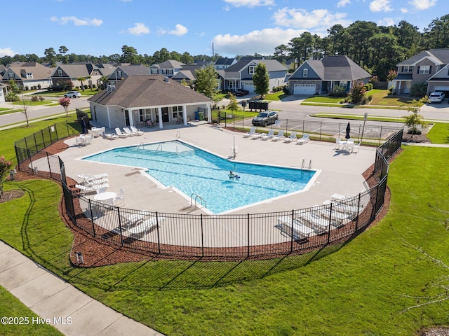 community pool with a residential view, a patio, and fence