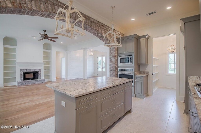 kitchen with visible vents, gray cabinets, appliances with stainless steel finishes, and decorative columns