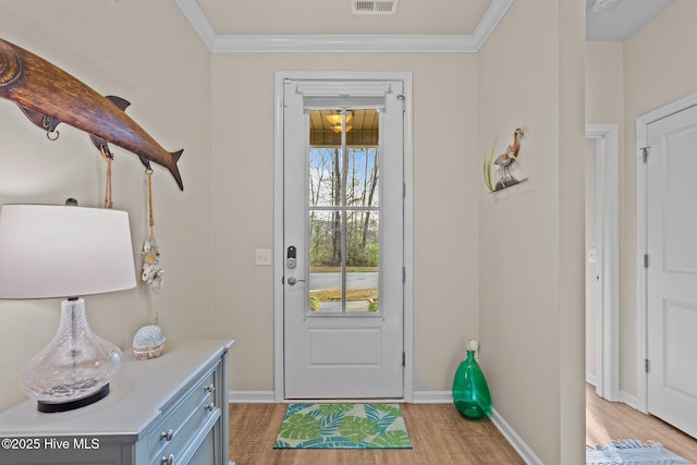 doorway to outside with visible vents, baseboards, light wood-style flooring, and crown molding