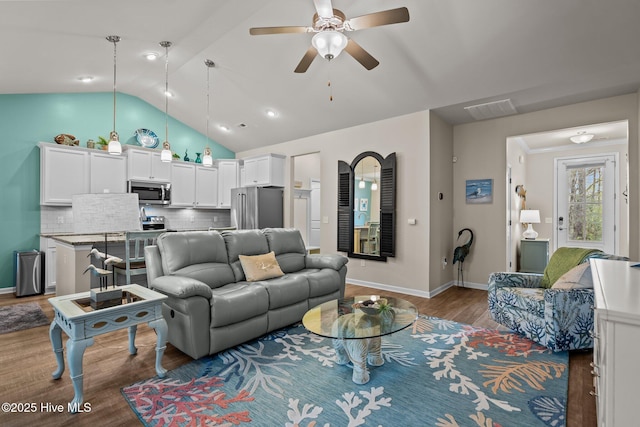 living area featuring visible vents, lofted ceiling, wood finished floors, baseboards, and ceiling fan