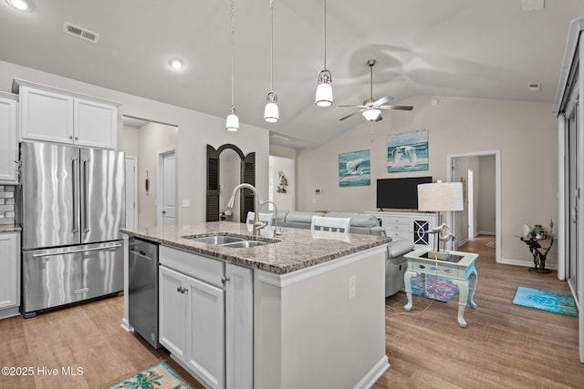 kitchen featuring visible vents, stainless steel appliances, light wood-style floors, white cabinetry, and a sink