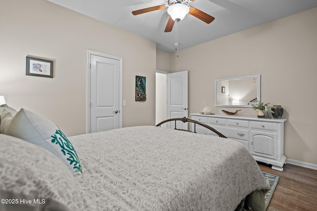 bedroom featuring baseboards, dark wood-style floors, and a ceiling fan