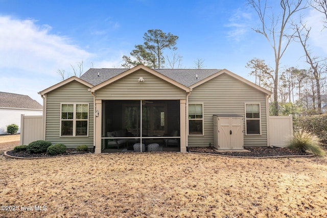 rear view of house with roof with shingles and a sunroom