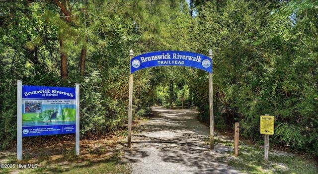 view of property's community featuring a view of trees and driveway