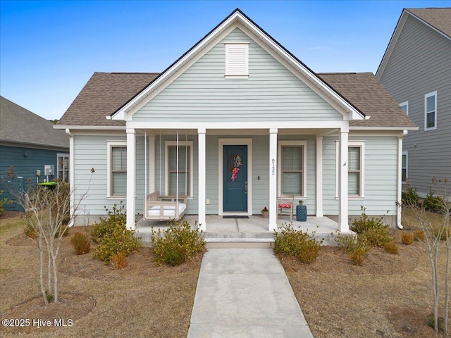 bungalow with covered porch and roof with shingles