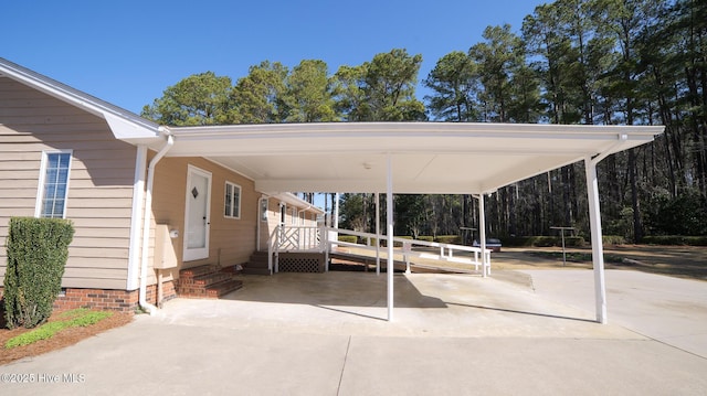 view of parking / parking lot with entry steps, an attached carport, and concrete driveway