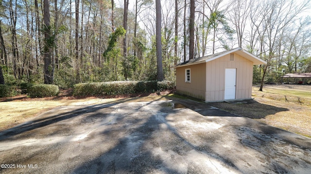 view of outdoor structure with an outbuilding and a forest view