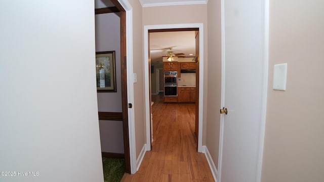 corridor featuring light wood-style floors and baseboards