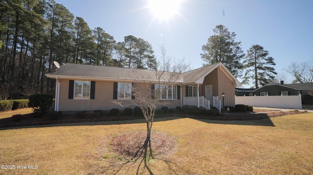 ranch-style house featuring a front yard and fence