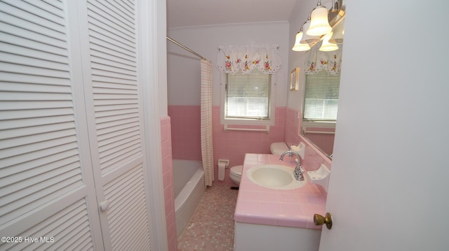 full bath featuring vanity, a closet, wainscoting, tile walls, and toilet