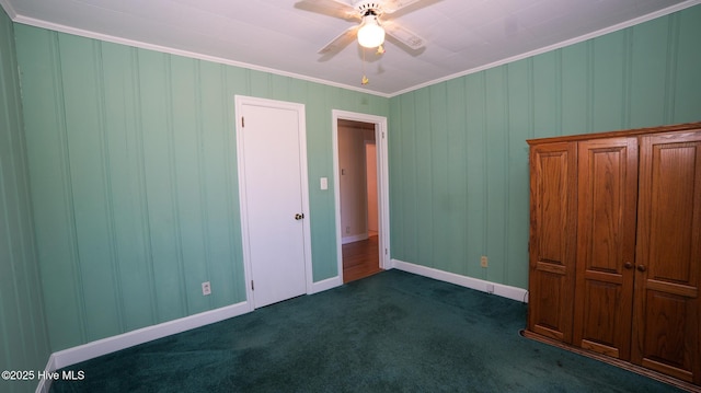 unfurnished bedroom featuring a ceiling fan, baseboards, dark carpet, and ornamental molding