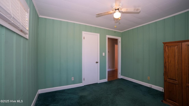 unfurnished room with ceiling fan, ornamental molding, and dark carpet