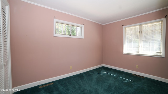 unfurnished room with visible vents, crown molding, baseboards, and dark colored carpet