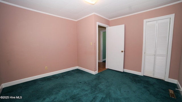 unfurnished bedroom with dark colored carpet, a closet, baseboards, and crown molding