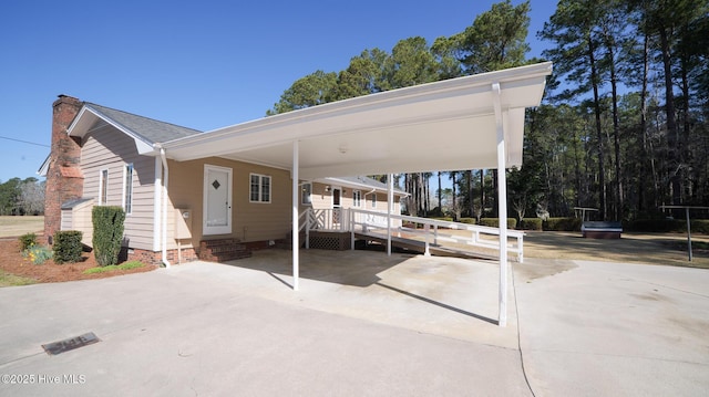 exterior space featuring entry steps, concrete driveway, and a carport