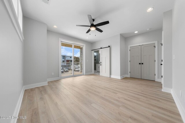 304 Alabama Ave Unit 2, Carolina Beach, NC 28428 - unfurnished bedroom with baseboards, a barn door, access to outside, and light wood finished floors