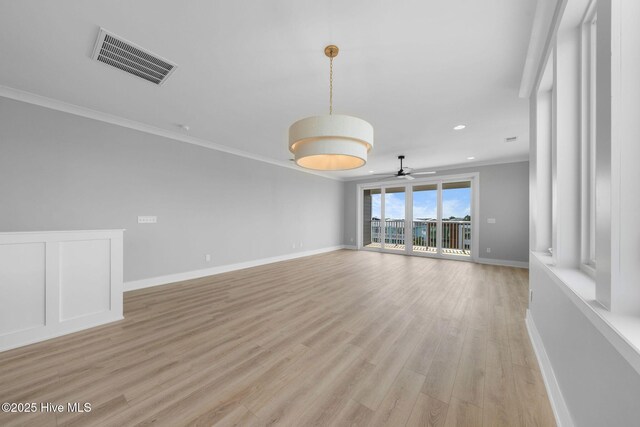 304 Alabama Ave Unit 2, Carolina Beach, NC 28428 - unfurnished living room featuring light wood-style floors, visible vents, baseboards, ornamental molding, and a ceiling fan