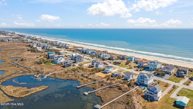 birds eye view of property with a water view and a beach view