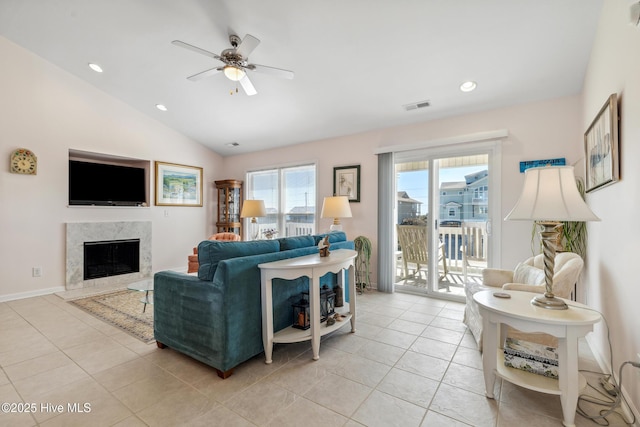 living area with visible vents, a ceiling fan, a high end fireplace, light tile patterned flooring, and lofted ceiling