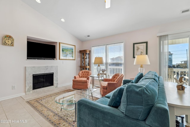 living room featuring tile patterned flooring, plenty of natural light, lofted ceiling, and a high end fireplace