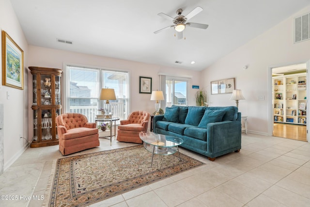 living area with light tile patterned floors, visible vents, lofted ceiling, and baseboards