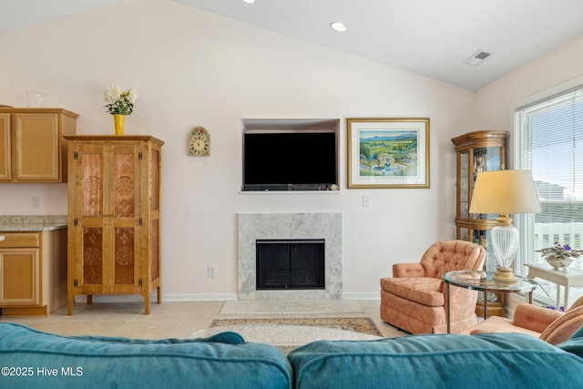 living area with light tile patterned flooring, visible vents, baseboards, and a premium fireplace