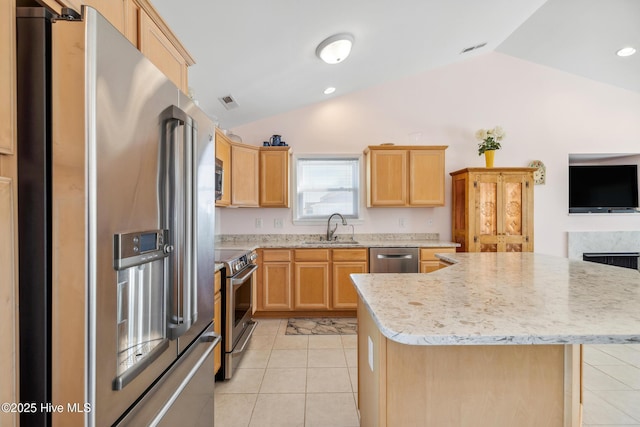 kitchen with light tile patterned floors, light brown cabinets, lofted ceiling, a sink, and appliances with stainless steel finishes