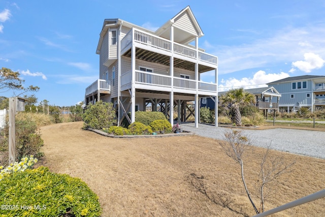 view of front of property with a carport, driveway, and a balcony