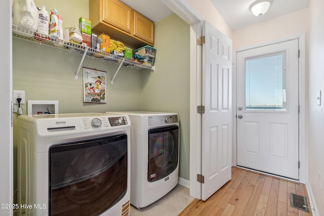 washroom with visible vents, baseboards, laundry area, light wood-style flooring, and washer and dryer