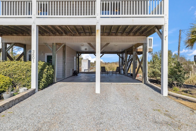 view of patio / terrace featuring stairway, a carport, and driveway