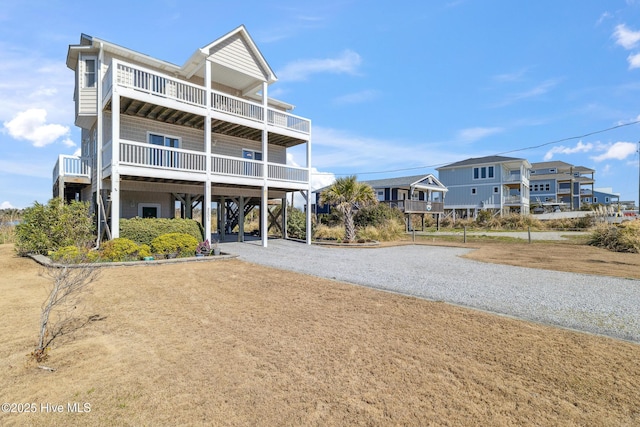 view of front of house featuring a carport, a balcony, and driveway