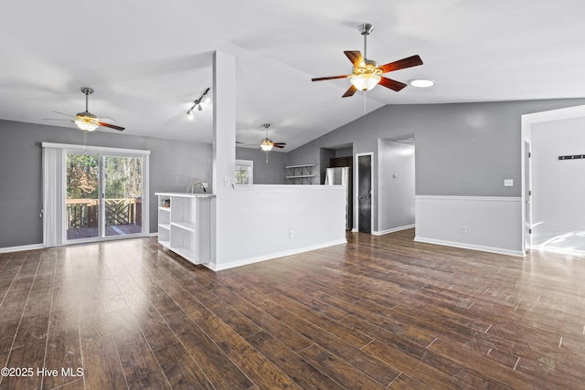 unfurnished living room featuring a ceiling fan, lofted ceiling, dark wood-style floors, and baseboards